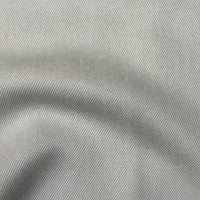 Close-up of Longan Craft’s Solid Color Denim Lyocell Fabric By The Yard, showing its light gray shade, diagonal twill weave, wrinkle-free texture, and soft folds for a breathable, comfy jean material.