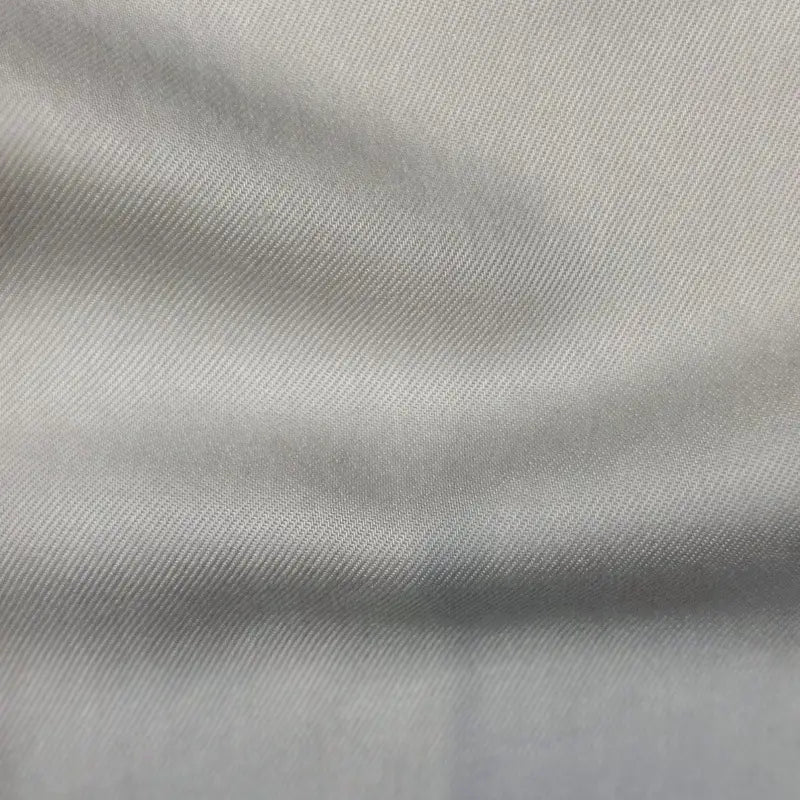 Close-up of Longan Craft's Solid Color Denim Lyocell Fabric By The Yard in light gray, showing its breathable, wrinkle-free texture with a subtle diagonal weave and soft folds—ideal for comfy jeans.