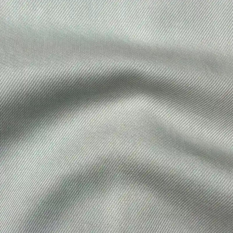 Close-up of Longan Craft’s Solid Color Denim Lyocell Fabric By The Yard, featuring a subtle diagonal weave and gentle folds—breathable, wrinkle-free, and comfy material perfect for sustainable jeans and fashion.