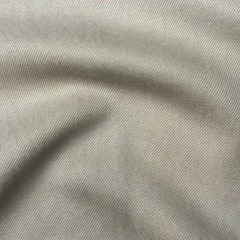 Close-up of Longan Craft’s Solid Color Denim Lyocell Fabric by the yard, showing fine diagonal lines and subtle folds. This breathable, comfy, wrinkle-free material is ideal for sustainable fashion and perfect for jeans.