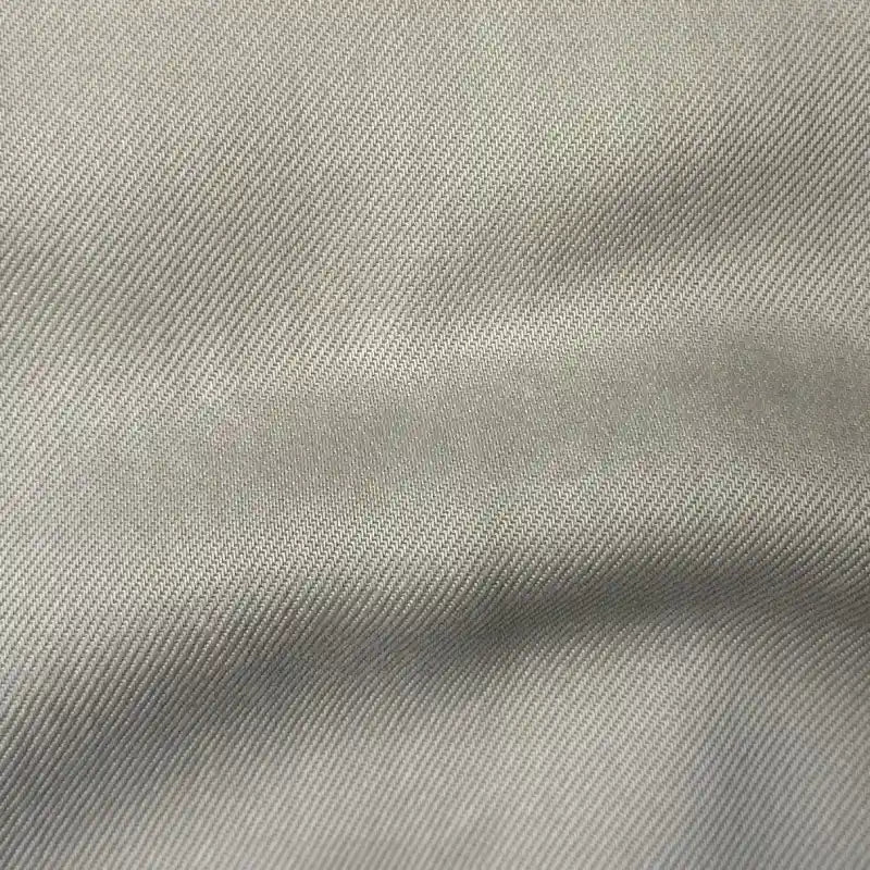 Close-up of Solid Color Denim Lyocell Fabric by Longan Craft, featuring a light gray diagonal weave with subtle shadows and creases. Wrinkle-free, breathable, and comfy—perfect material for sustainable jeans or eco-friendly fashion projects.