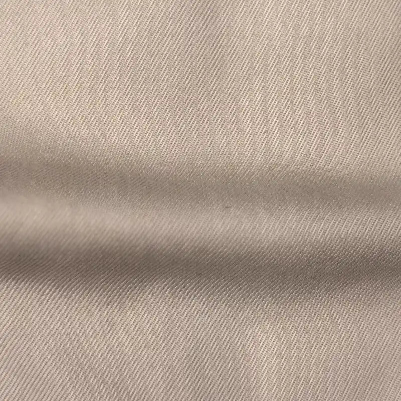 Close-up of Longan Craft’s Solid Color Denim Lyocell Fabric By The Yard shows its visible diagonal weave and horizontal fold, highlighting this wrinkle-free, breathable textile—perfect for stylish and sustainable jeans.
