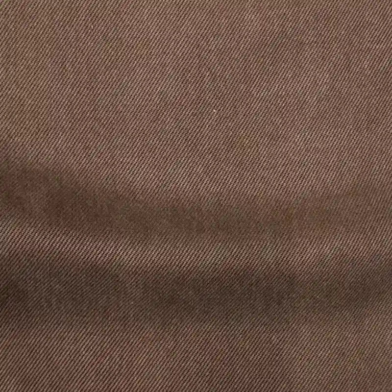 Close-up of Longan Craft’s Solid Color Denim Lyocell Fabric By The Yard—wrinkle-free, breathable, and comfy with a brown diagonal weave, smooth texture, and subtle shading—ideal for stylish, sustainable jeans.