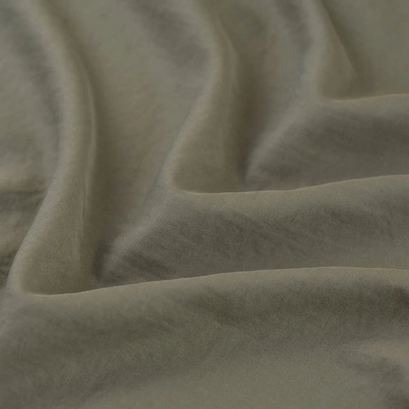 Close-up of Longan Craft's olive green Solid Color Double Sided Peachskin Fabric By The Yard, a soft microfiber polyester material with smooth peachskin texture and gentle folds, perfect for dresses.