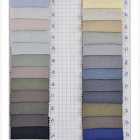 Two columns of Longan Craft Solid Color Double Sided Peachskin Fabric swatches in gray, blue, beige, and tan are arranged vertically on grid paper. Each polyester blend microfiber swatch has a handwritten blue number label on the left.
