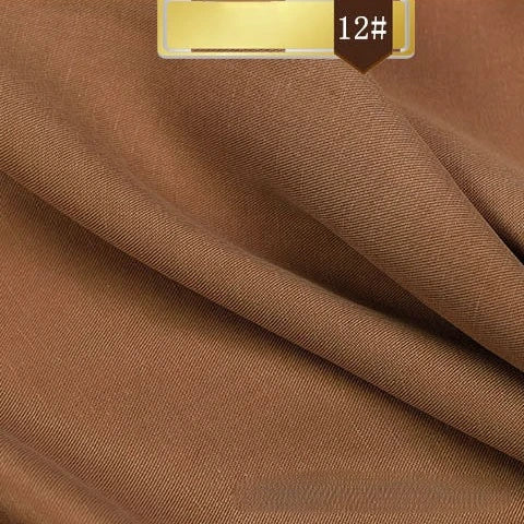 A close-up of light brown Solid Color Linen Lyocell Fabric by Longan Craft shows a fine twill weave and soft folds. A gold-brown label with code 12# highlights this sustainable, breathable, and wrinkle-free material for dresses.