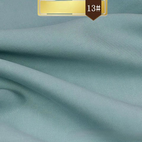 Solid Color Linen Lyocell Fabric By The Yard from Longan Craft features a soft, smooth, light blue surface with a subtle sheen and drapes beautifully. A brown label with "13#" in white highlights this sustainable, wrinkle-free twill for dresses.
