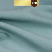 Solid Color Linen Lyocell Fabric By The Yard from Longan Craft features a soft, smooth, light blue surface with a subtle sheen and drapes beautifully. A brown label with "13#" in white highlights this sustainable, wrinkle-free twill for dresses.