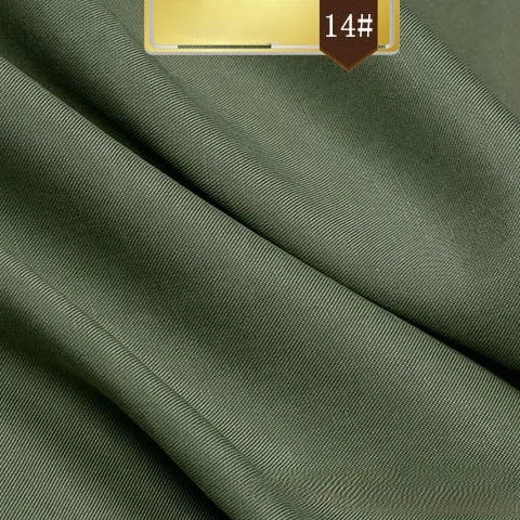 Longan Craft’s Solid Color Linen Lyocell Fabric by the yard features a smooth, slightly glossy olive green finish. Wrinkle-free and sustainable, this breathable twill fabric is ideal for dresses. A 14# label appears in white on a brown background.