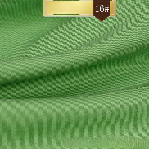 Close-up of smooth, green Solid Color Linen Lyocell Fabric By The Yard from Longan Craft with subtle folds. A gold label at the top reads 16#. Wrinkle-free, sustainable, and breathable twill material—ideal for dresses.