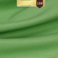 Close-up of smooth, green Solid Color Linen Lyocell Fabric By The Yard from Longan Craft with subtle folds. A gold label at the top reads 16#. Wrinkle-free, sustainable, and breathable twill material—ideal for dresses.