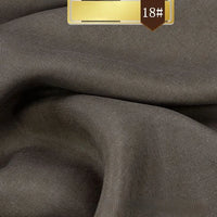 Close-up of Longan Craft’s Solid Color Linen Lyocell Fabric By The Yard in brown, featuring a smooth texture and gentle folds; a gold label with 18# appears at the top. This sustainable, wrinkle-free twill lyocell is ideal for dresses.