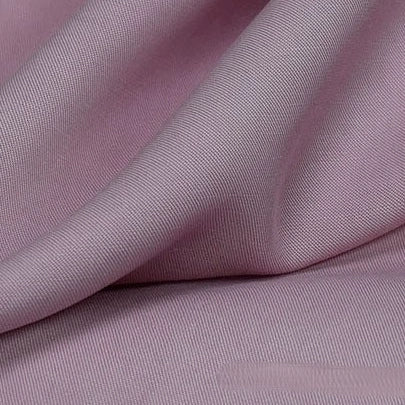 Close-up of Longan Craft’s Solid Color Linen Lyocell Fabric by the yard, featuring a soft light mauve hue, smooth wrinkle-free twill texture, gentle folds, and subtle sheen—sustainable and breathable for dresses.