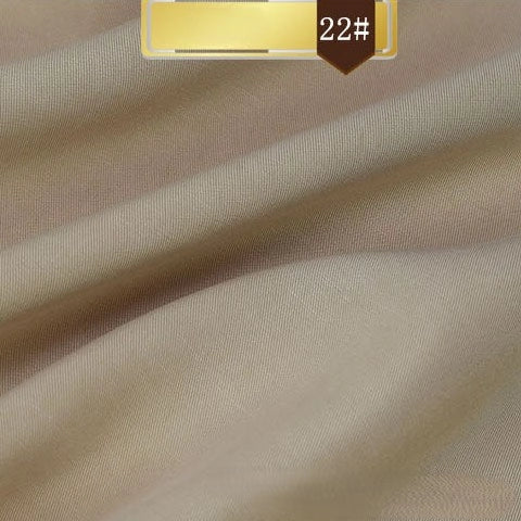 Close-up of Longan Craft's Solid Color Linen Lyocell Fabric By The Yard in light beige with soft diagonal folds and a gold "22#" label. This wrinkle-free, smooth, and sustainable lyocell twill is ideal for dresses.