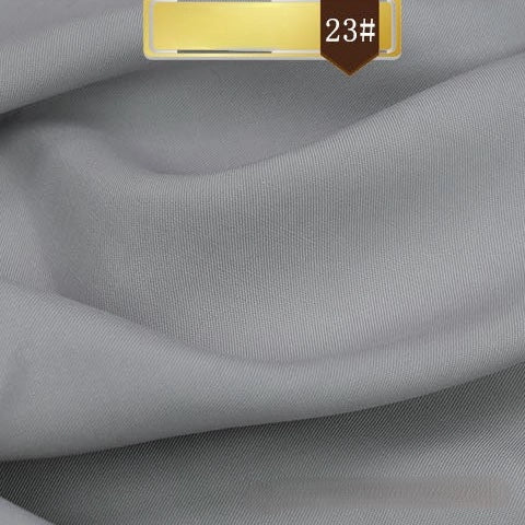 Close-up of smooth light gray Solid Color Linen Lyocell Fabric By The Yard from Longan Craft, with a gold and brown "23#" label. This sustainable, wrinkle-free twill lyocell is breathable—ideal for elegant, comfortable dresses.