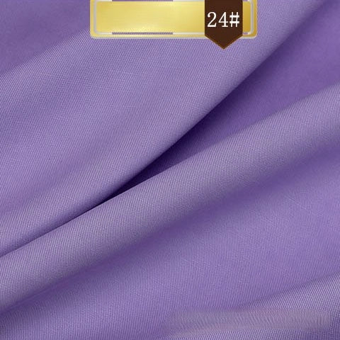 A close-up of smooth, folded purple Solid Color Linen Lyocell Fabric by Longan Craft, featuring a gold and brown 24# label. This wrinkle-free, sustainable textile blends elegance with eco-friendly lyocell for breathable dresses.