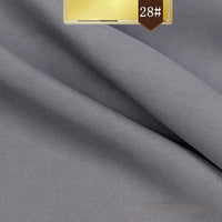 Close-up of smooth, light gray Solid Color Linen Lyocell Fabric by Longan Craft, featuring a soft texture and fine twill weave. A golden 28# label highlights this sustainable, wrinkle-free fabric ideal for dresses.