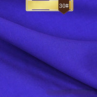 A close-up of Longan Craft’s Solid Color Linen Lyocell Fabric By The Yard shows its vibrant royal blue, smooth wrinkle-free twill texture, and neat folds. A brown "30#" label highlights this sustainable, breathable textile ideal for dresses.