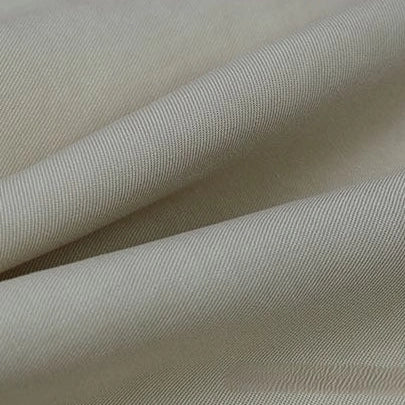 A close-up of Longan Craft’s Solid Color Linen Lyocell Fabric By The Yard reveals its smooth, wrinkle-free twill texture, subtle diagonal weave, and gentle folds—an eco-friendly, breathable material ideal for dresses.