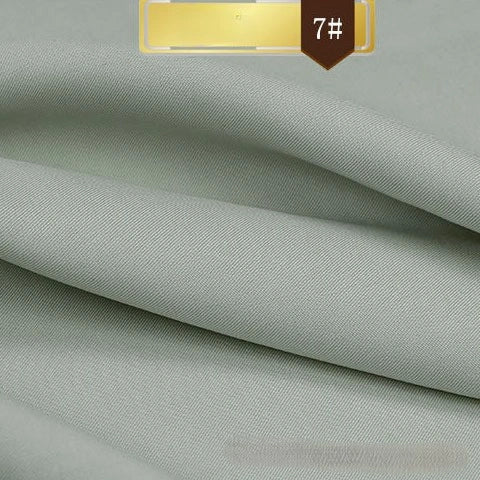 Solid Color Linen Lyocell Fabric by Longan Craft shown in light grey, folded in smooth, textured layers with a gold and brown "7#" label. Wrinkle-free, sustainable twill lyocell—ideal for dresses.