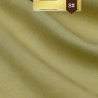 Close-up of wrinkle-free, light gold Solid Color Linen Lyocell Fabric by Longan Craft with soft folds. A brown label at the top right shows “8#” and a gold rectangle, possibly indicating this sustainable textile’s color or style code.
