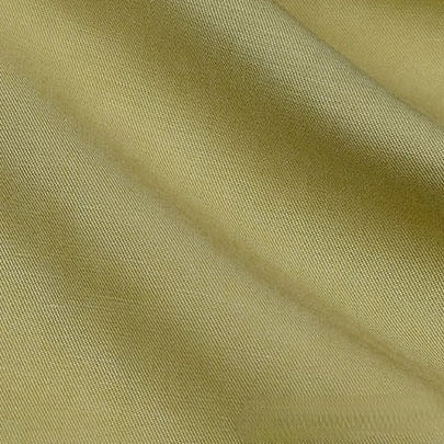 A close-up of Longan Craft’s Solid Color Linen Lyocell Fabric By The Yard shows its light olive green, wrinkle-free twill lyocell material with a soft sheen, diagonal weave, and gentle folds—sustainable and breathable for dresses.