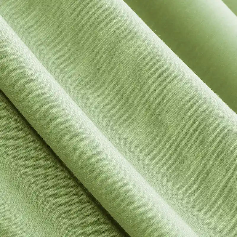 Close-up of Longan Craft's Solid Color Modal Jersey Fabric by the Yard, a light green cotton spandex textile with a smooth, soft texture, draped in gentle folds—ideal for breathable sleepwear.