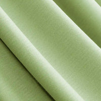 Close-up of Longan Craft's Solid Color Modal Jersey Fabric by the Yard, a light green cotton spandex textile with a smooth, soft texture, draped in gentle folds—ideal for breathable sleepwear.