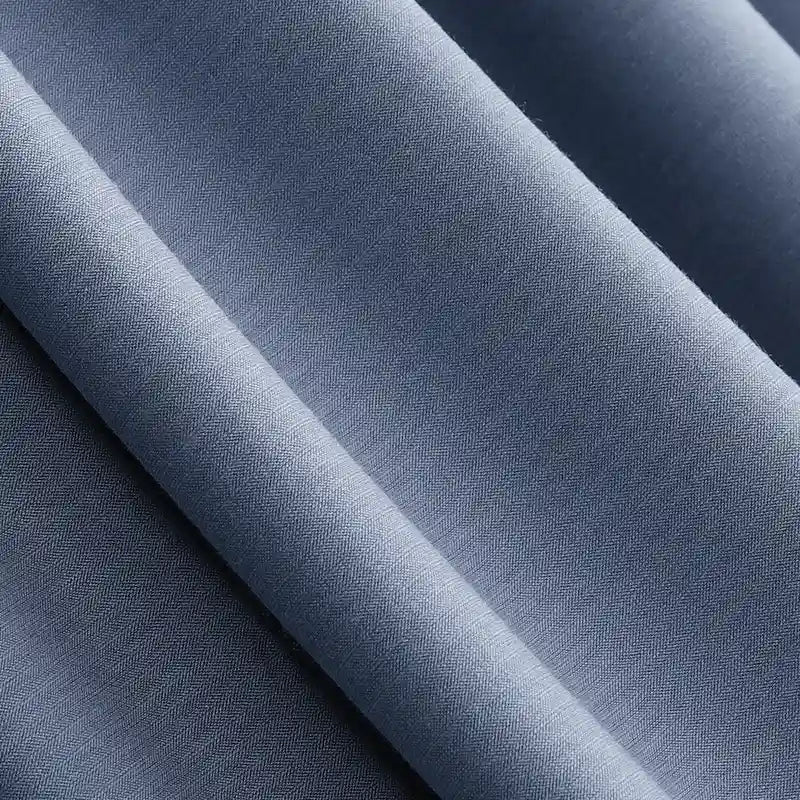 Close-up of Longan Craft's Solid Color Modal Jersey Fabric by the Yard, a breathable cotton spandex jersey textile in light blue with a subtle fine texture, showing soft shadows and highlights on its smooth folds—ideal for sleepwear.