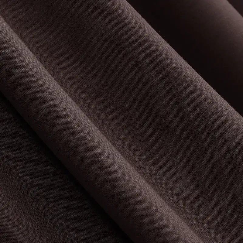 Close-up of Longan Craft’s Solid Color Modal Jersey Fabric by the yard, a cotton spandex textile ideal for sleepwear, shown in dark brown with subtle diagonal folds that highlight its soft, breathable texture and fine weave.