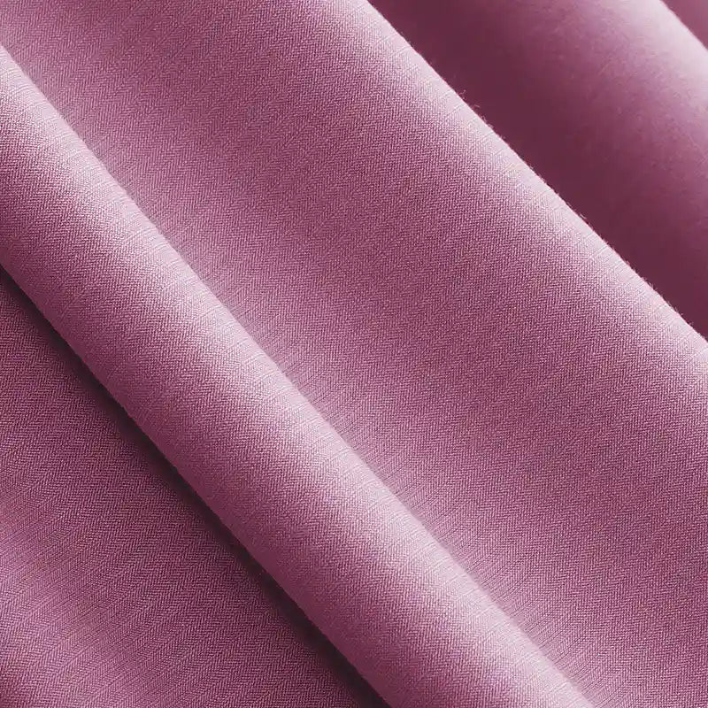 A close-up of Longan Craft Solid Color Modal Jersey Fabric By The Yard showcases its soft, smooth texture and gentle folds. This breathable cotton spandex jersey textile is ideal for sleepwear and features a slightly textured purple surface.