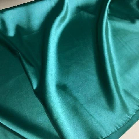 A close-up of Longan Craft's Solid Color Polyester Satin Fabric shows its silky stretch texture, smooth gentle folds, and subtle sheen in a solid teal shade—perfect satin material for blouses, sold by the yard.