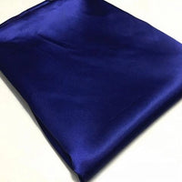 A neatly folded piece of Longan Craft’s royal blue Solid Color Polyester Satin Fabric By The Yard showcases its silky stretch satin texture and rich glossy finish, making it perfect for blouses.