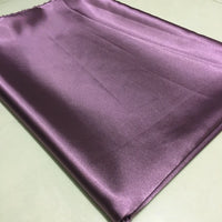 Longan Craft Solid Color Polyester Satin Fabric by the yard in purple, with a silky stretch satin texture, is laid flat to show its glossy finish and gentle folds—ideal satin material for blouses.