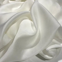 The Solid Color Ramie Fabric By The Yard from Longan Craft features a super lightweight lyocell ramie material in a soft, white hue. Draped in gentle folds, this breathable fabric creates smooth, flowing curves with a subtle sheen—perfect for blouses that offer both refined style and lasting comfort.