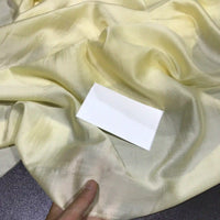 A hand holds a piece of Longan Craft’s Solid Color Ramie Fabric By The Yard—super lightweight, shiny, and breathable lyocell ramie material for blouses—with a blank white rectangular card placed on it.