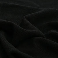 Close-up of Longan Craft’s Solid Color Rayon Linen Fabric By The Yard—thick, washed slub viscose with a soft, textured surface in solid black, ideal for dresses and clothing. Subtle folds create gentle shadows and highlights.