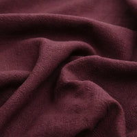 Close-up of Longan Craft's Solid Color Rayon Linen Fabric by the Yard, a thick, washed slub viscose with a soft, textured feel in rich maroon, featuring gentle folds and creases for added depth—perfect for dresses and apparel.