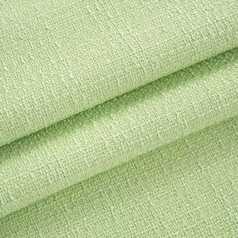 Close-up of Longan Craft’s Solid Color Tweed Fabric By The Yard reveals its light green woven polyester surface, subtle raised patterns, and thickness—perfect as a chic tweed textile for suits.