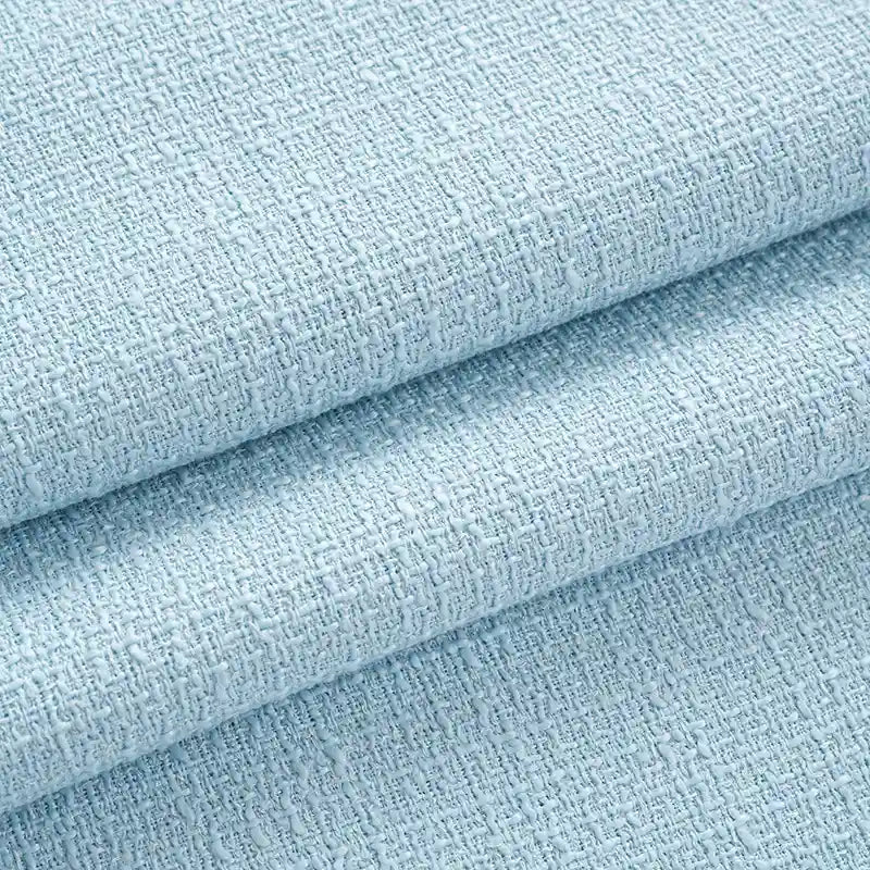 Close-up of Longan Craft's Solid Color Tweed Fabric By The Yard, a woven polyester textile in light blue with a soft, thick texture and detailed surface—ideal chic tweed material for suits and clothing.