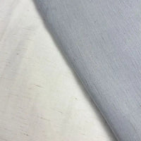 Close-up of two pieces of Longan Craft Solid Color Viscose Lyocell Fabric by the yard, one white and one light gray, with a visible seam. This smooth, breathable rayon-linen blend textile features a slightly textured, woven appearance.
