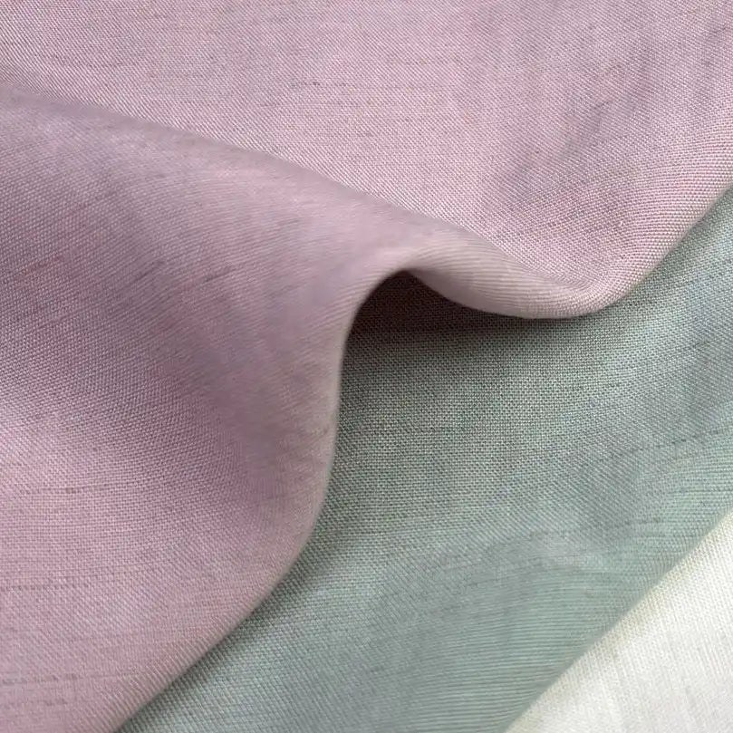 Close-up of Longan Craft's Solid Color Viscose Lyocell Fabric By The Yard, a rayon and linen blend in soft pastel pink, grayish-green, and off-white—smooth, breathable, eco-friendly textile perfect for tops.