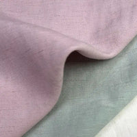 Close-up of Longan Craft's Solid Color Viscose Lyocell Fabric By The Yard, a rayon and linen blend in soft pastel pink, grayish-green, and off-white—smooth, breathable, eco-friendly textile perfect for tops.