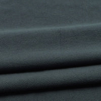 Close-up of folded Solid Color Washed Crepe Fabric by the yard from Longan Craft, made from 100% cotton with a soft, slightly textured crepe surface in dark gray, displaying subtle creases—ideal for pants and other clothing projects.