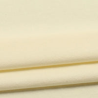 Close-up of neatly folded Longan Craft Solid Color Washed Crepe Fabric by the yard in pale yellow, made from 100% cotton with a soft textured surface, displaying gentle shadows and subtle creases along the edges.
