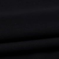 A close-up of Longan Craft’s Solid Color Washed Crepe Fabric By The Yard, crafted from 100% cotton crepe for clothing, showcases its smooth, matte black surface with gentle folds and a soft, textured finish that creates delicate shadows and highlights.