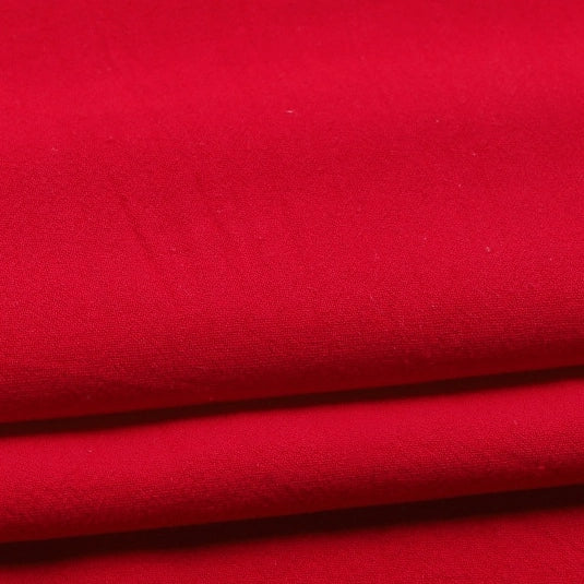 Here’s a rewritten sentence using your provided product data: Close-up of Longan Craft’s Solid Color Washed Crepe Fabric By The Yard, made from 100% cotton. The bright red crepe material is neatly folded in layers, showcasing its smooth, slightly matte finish and soft textured surface—perfect for pants and other clothing projects.