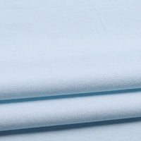 Longan Craft’s Solid Color Washed Crepe Fabric by the Yard is shown here in light blue, folded neatly to highlight its 100% cotton composition and soft, textured crepe surface. The gentle shadows between the layers emphasize the fabric’s smooth drape—ideal for pants or other clothing projects.