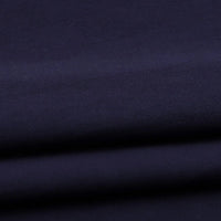A close-up of Longan Craft Solid Color Washed Crepe Fabric by the yard, made from 100% cotton with a soft, textured surface in dark navy blue, featuring gentle folds and subtle shadows—ideal for pants and clothing projects.