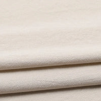 Three layers of light beige, softly textured Longan Craft Solid Color Washed Crepe Fabric are neatly stacked, forming gentle folds and delicate shadows. The surface displays a slightly rough texture, highlighting the 100% cotton crepe material’s natural feel and solid color finish—ideal for clothing and pants.